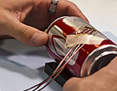 pop can with strain gage attached, preforming test