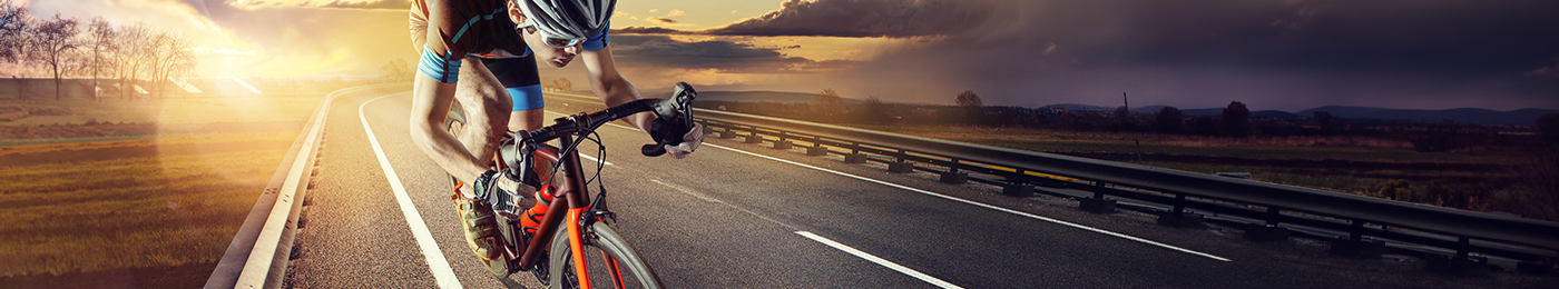 athletic bicyclist peddling fast on road