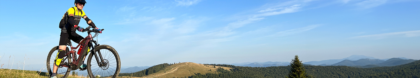 man on an e-bike overlooking fields and mountains