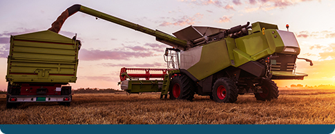 A farming combine spaying grain into a truck