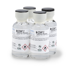 Four bottles of clear liquid labeled M-Coat C